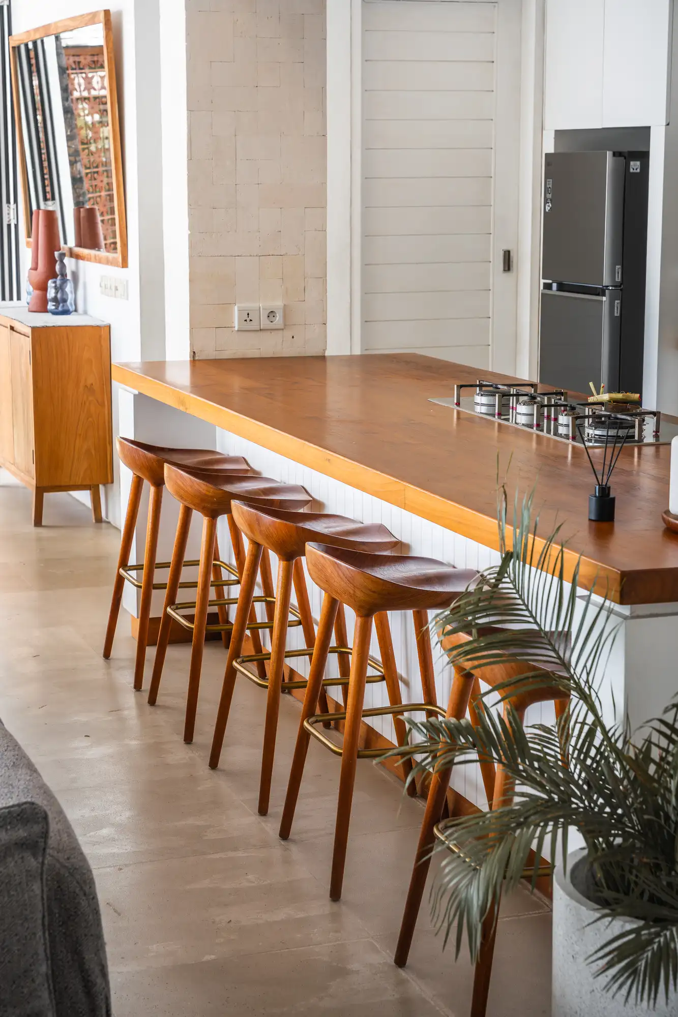 Kitchen island with teakwood bar stools and terracotta detailing at Lago Beach House Nusa Lembongan