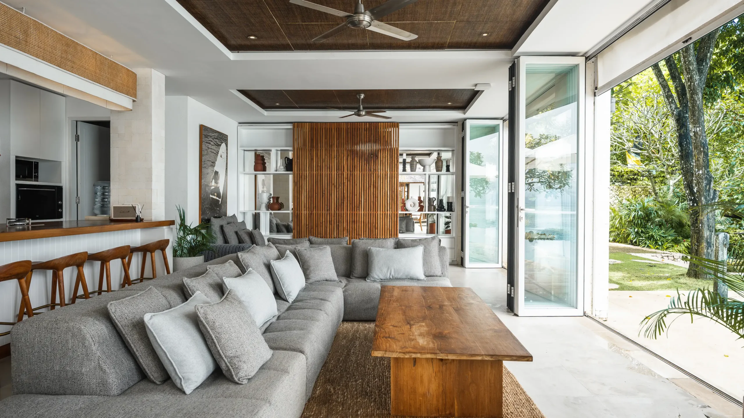 Open-plan living room and kitchen with bifold doors to the garden at Lago Beach House Nusa Lembongan