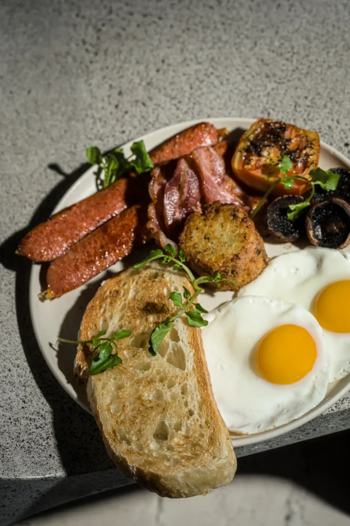 Full breakfast with fried eggs, bacon, sausage and sourdough at Dawn cafe Lago Nusa Lembongan