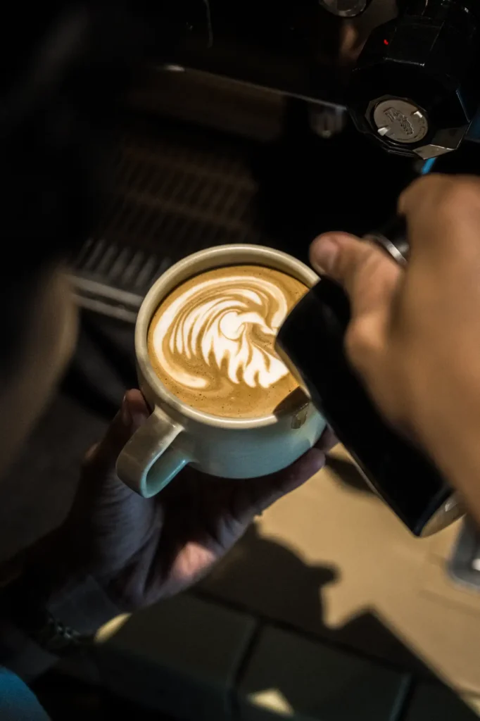 Latte with rosetta art in a pale-blue ceramic cup at Dawn cafe Lago Nusa Lembongan
