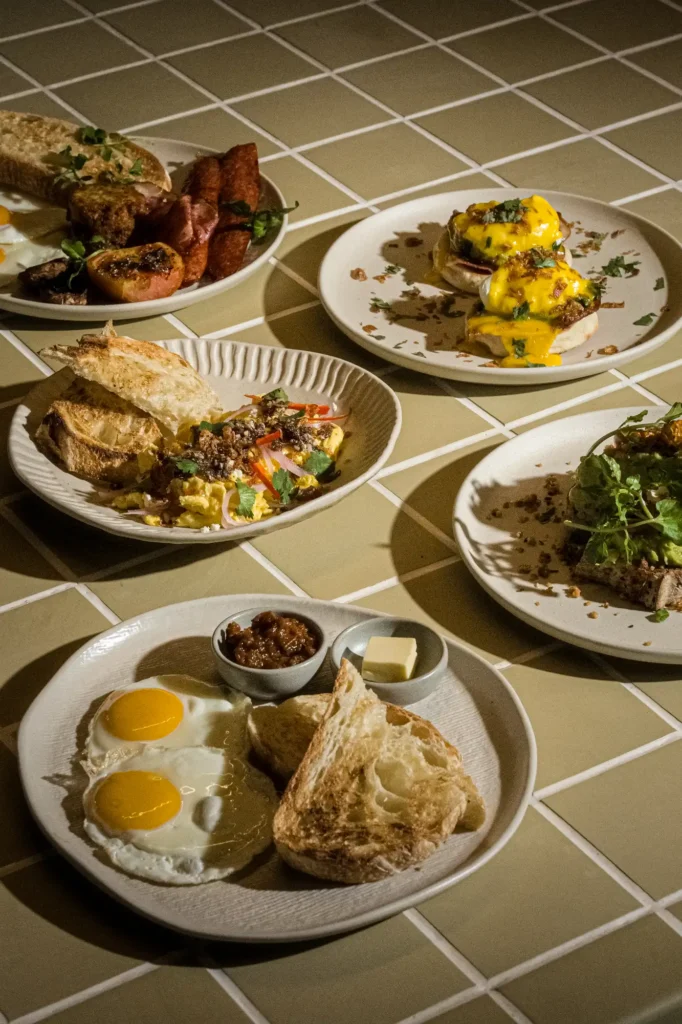 Tabletop spread of breakfast plates on green tile at Dawn cafe Lago Nusa Lembongan